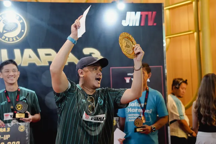 Champion raising the medal on stage